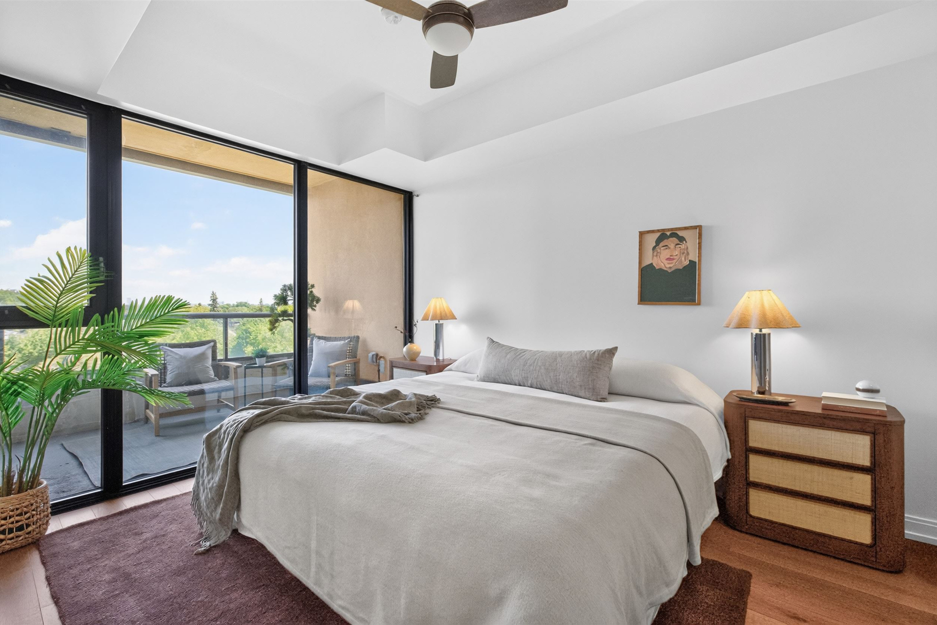 Primary bedroom with balcony access and large windows