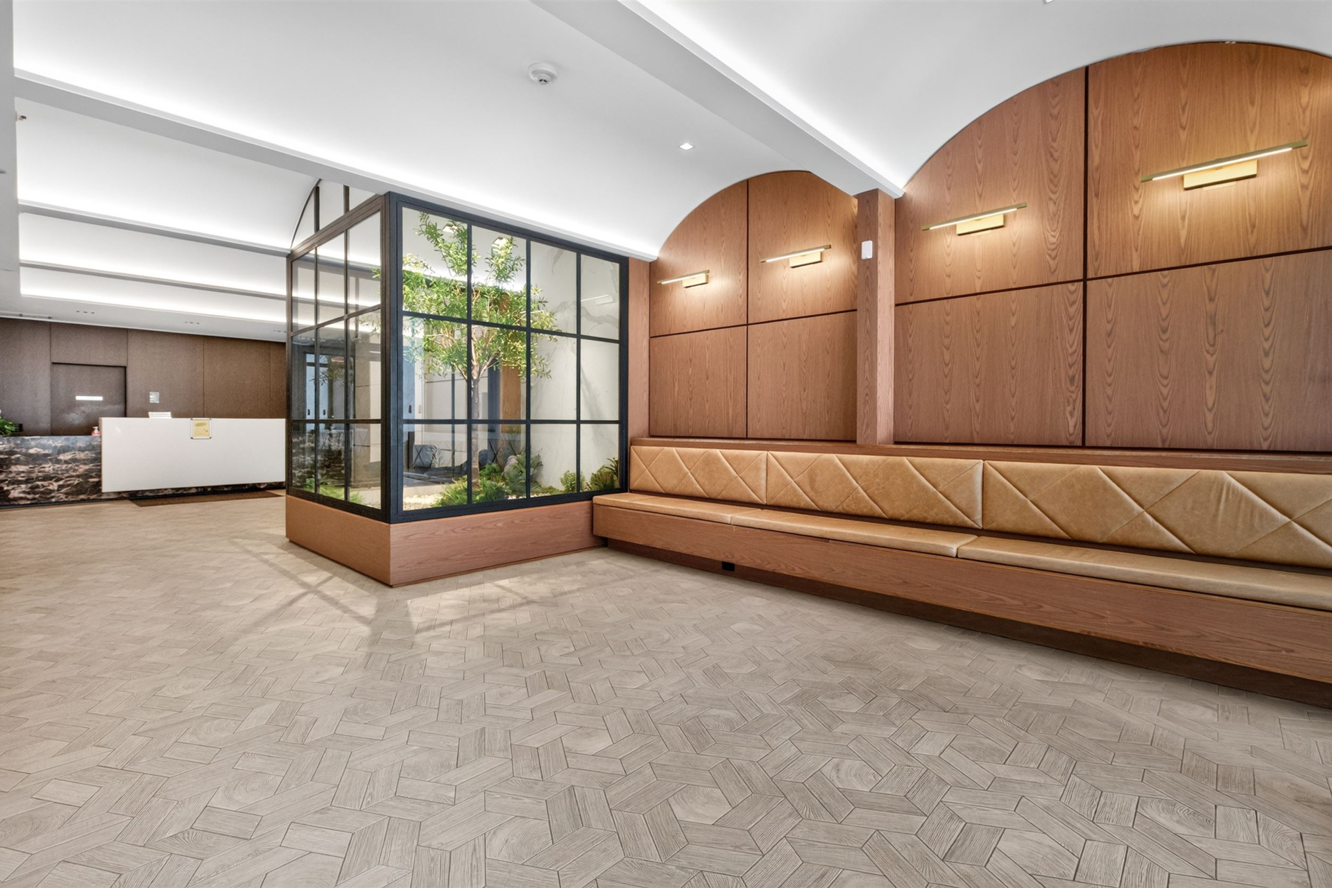 Building lobby with interior garden and banquette seating
